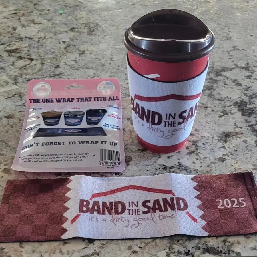 Red and white coffee cup with 'Band in the Sand' branding on a countertop.